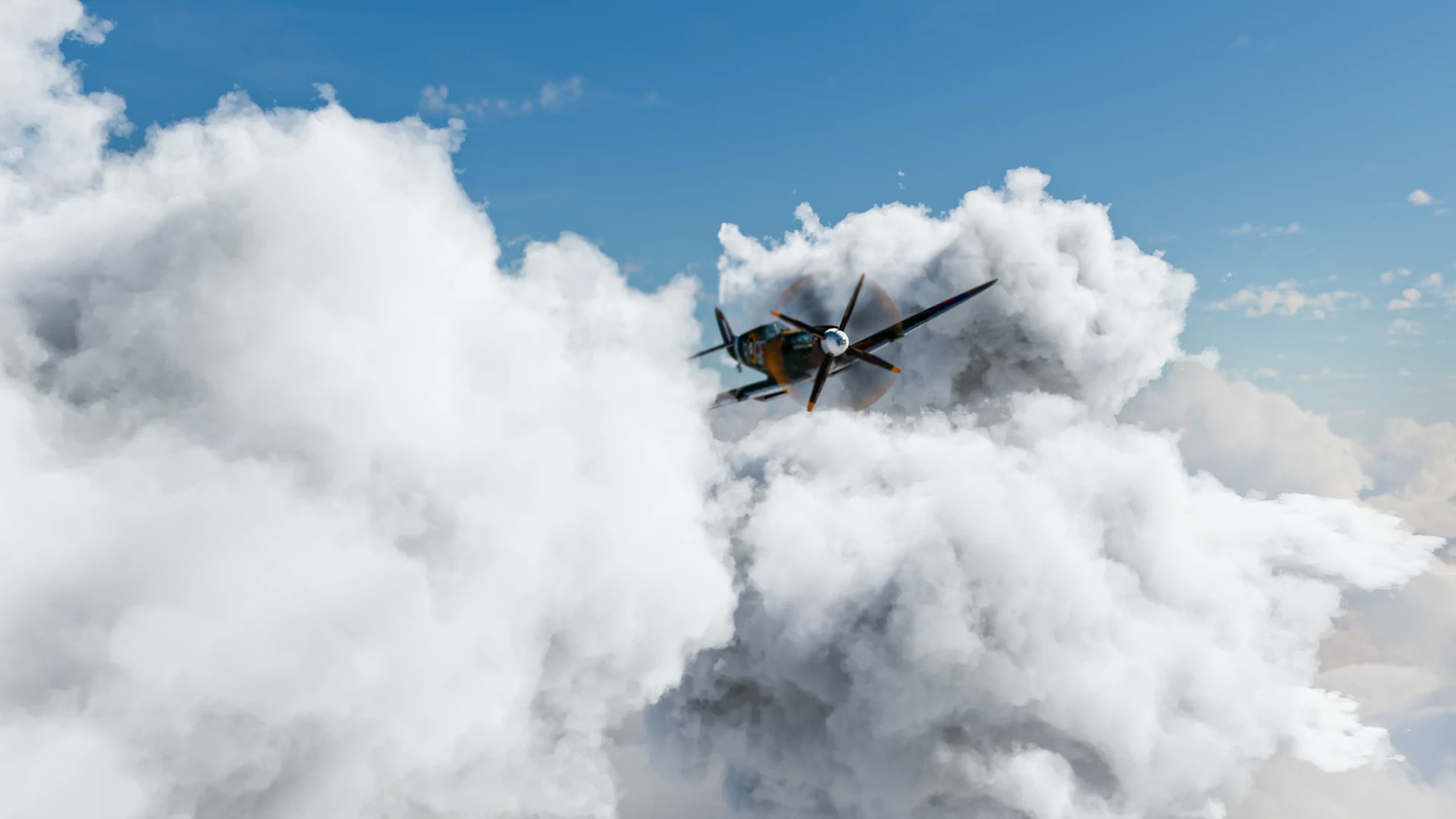 The Spitfire flying nose-on through towering white clouds under a blue sky, its propeller a blur